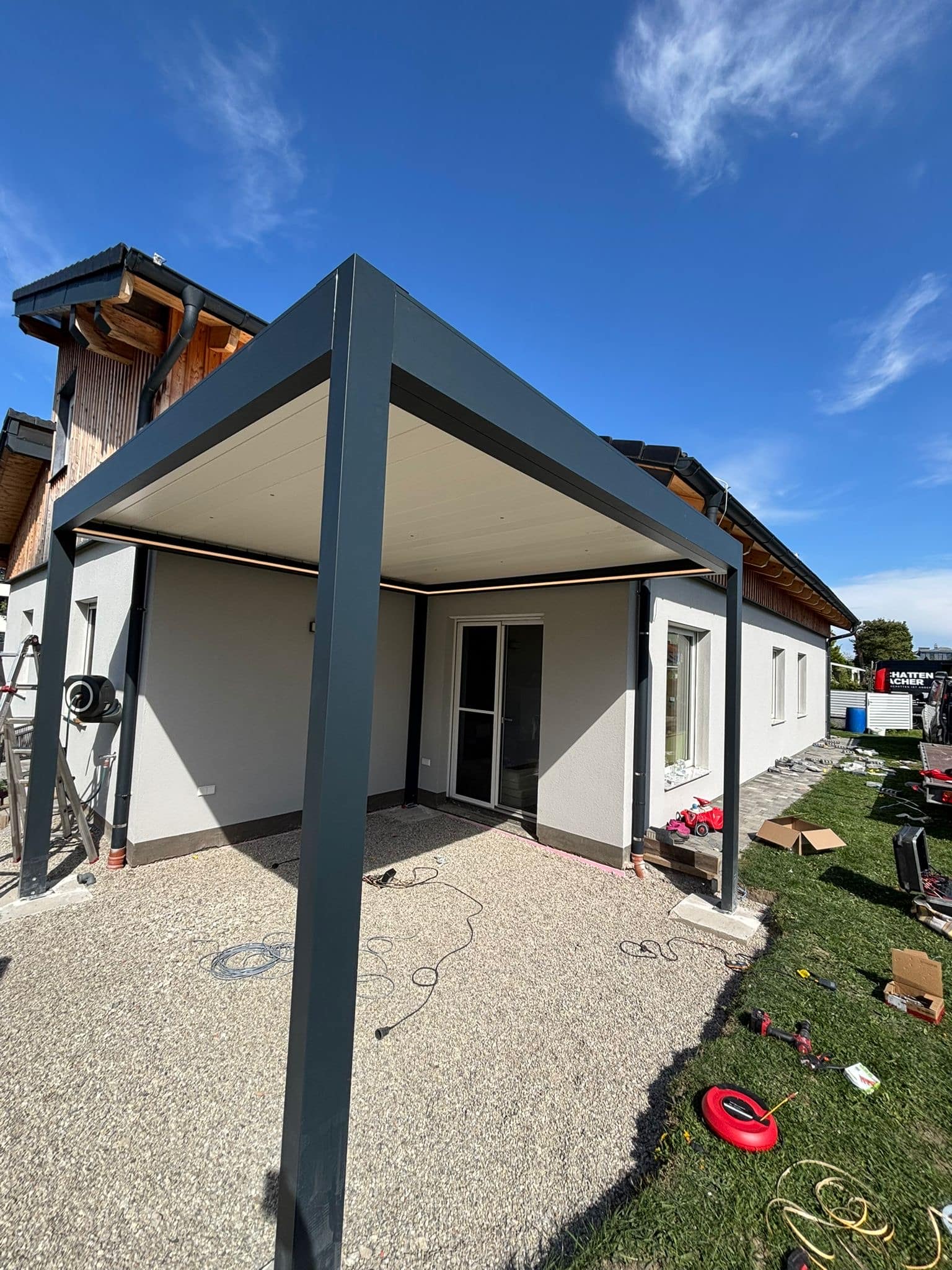Modernes Lamellendach über der Terrasse eines Einfamilienhauses