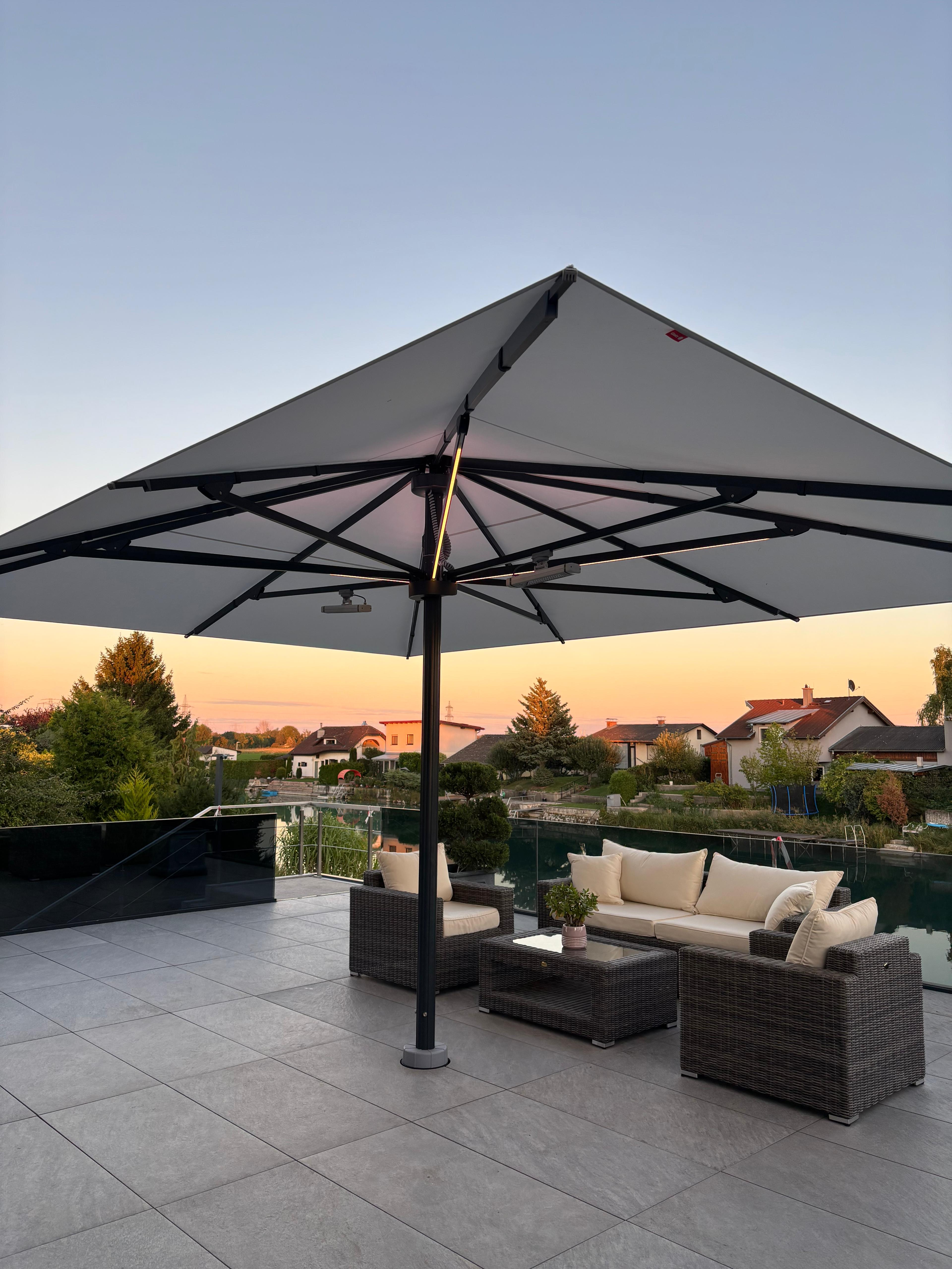 Freiarm-Sonnenschirm über dem Lounge-Bereich am Wasser